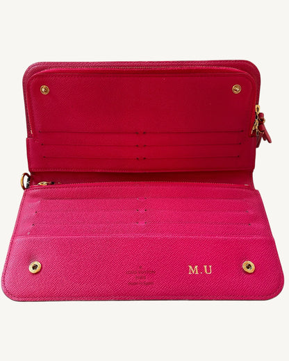 Louis Vuitton Insolite wallet opened to show pink leather card slots, gold-tone snaps and M.U personalization.