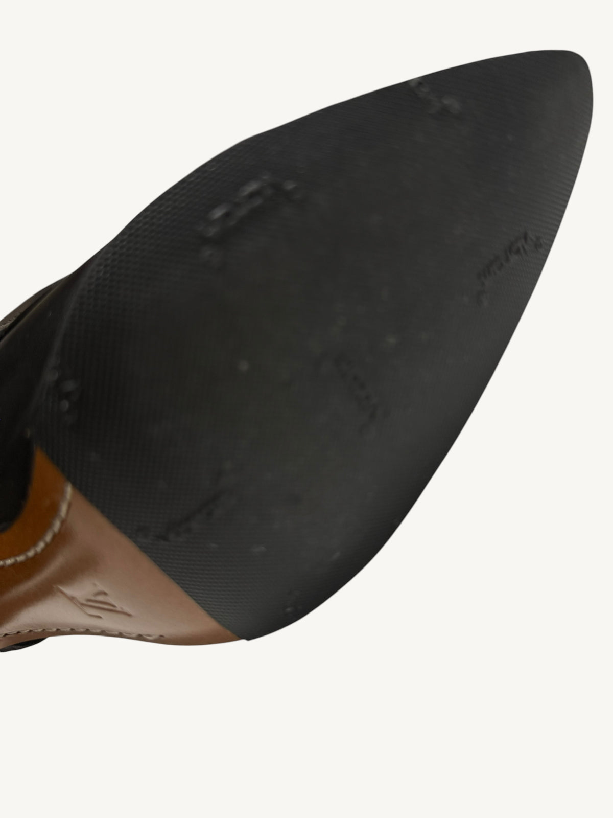 Close-up of a black rubber half-sole, showing its fine textured surface and visible wear marks.