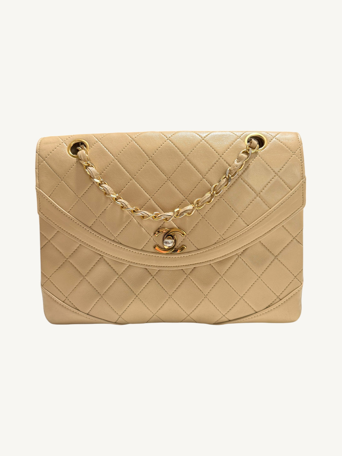 A beige quilted leather Chanel handbag with a gold chain strap and a gold interlocking CC logo clasp, photographed against a plain off-white background.