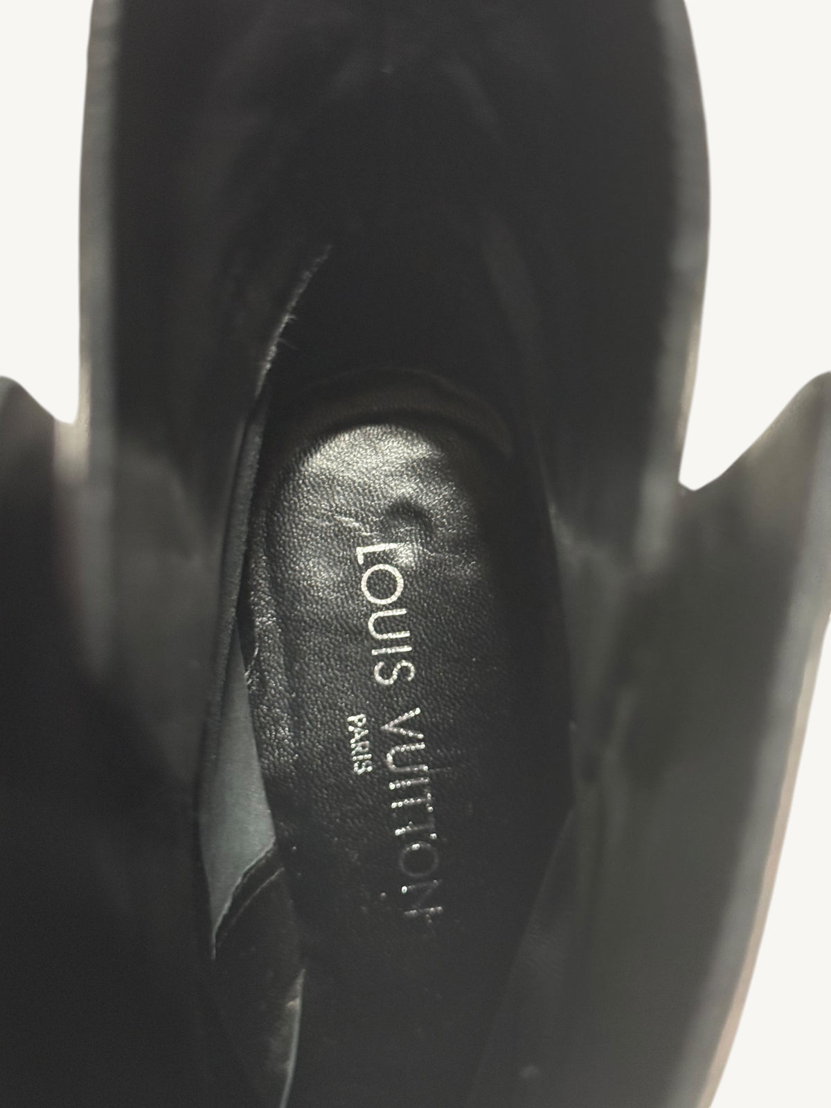 Inside a black leather boot, showing the Louis Vuitton Paris name printed on the insole.