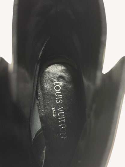 Inside a black leather boot, showing the Louis Vuitton Paris name printed on the insole.
