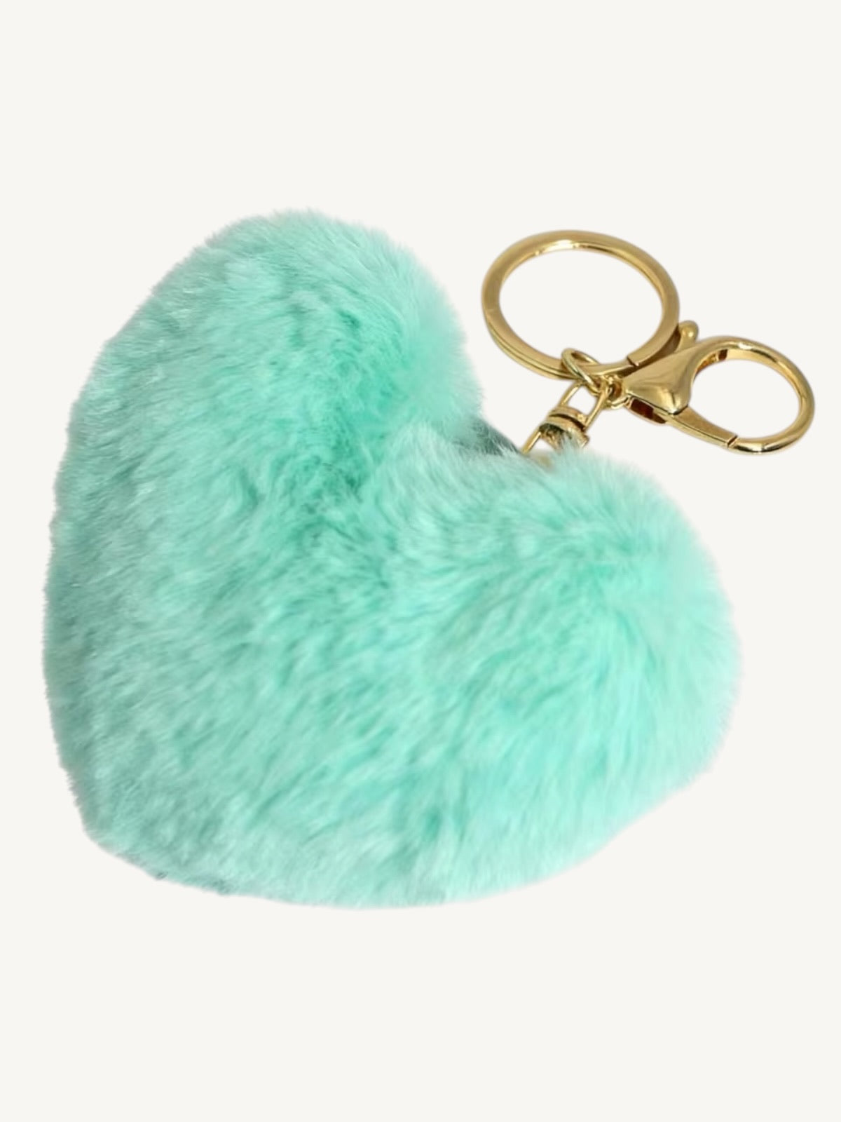 A mint green faux fur heart-shaped keychain with a gold-tone metal split ring and clasp, shown on a plain off-white background.