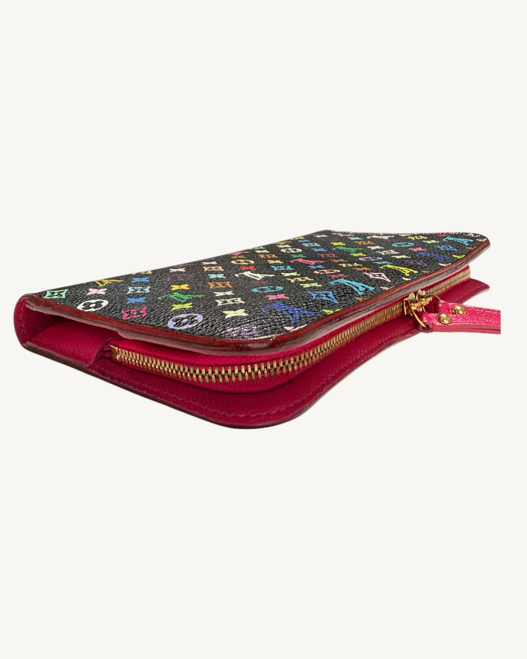 Opposite angled side view of the black Multicolore Insolite wallet with Grenade pink leather and gold-tone zipper.