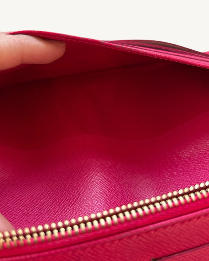 Close-up inside the Louis Vuitton Insolite wallet's pink leather zip pocket showing minor coin residue.