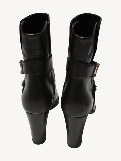 Rear view of black Louis Vuitton ankle boots, showing back seams, ankle straps and tall block heels.