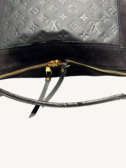 Louis Vuitton Audacieuse MM Infini — back view showing monogram empreinte embossing, double gold-tone zipper pulls and hand strap

