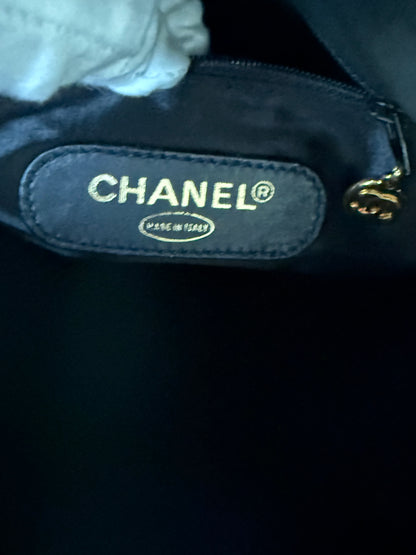 Close-up of BLACK Chanel  bag interior with a sewn-on CHANEL label and a gold-tone zipper pull.