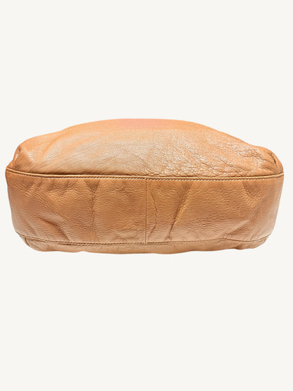 The bottom of camel brown Gucci leather  shown against a plain off-white background.
