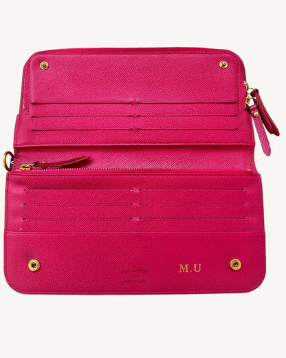 Flat-open Louis Vuitton Insolite wallet with Grenade pink interior, 12 card slots, zipper and gold-foil M.U initials.