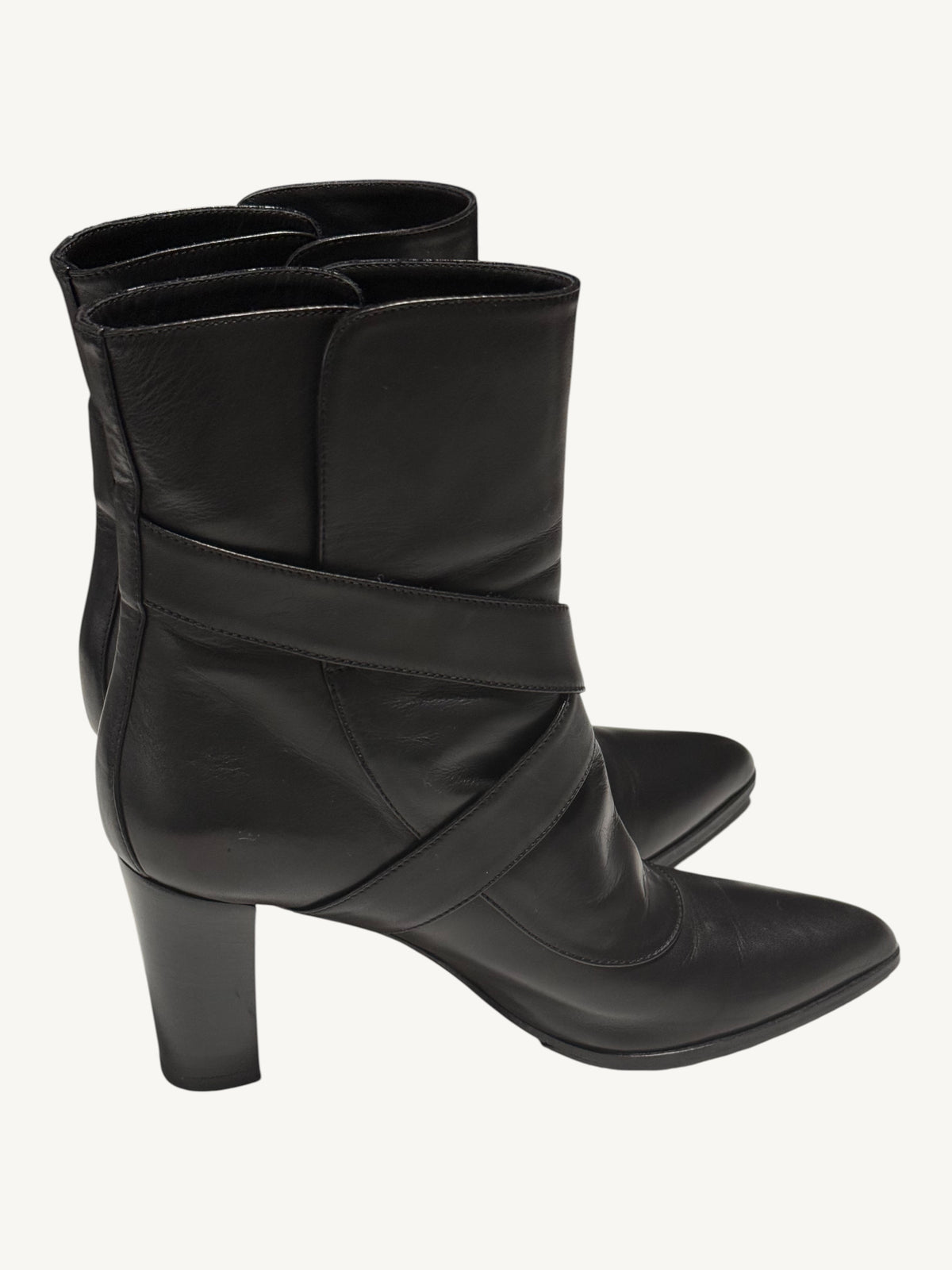 Side view of black Louis Vuitton boots with wraparound straps, pointed toes and block heels.