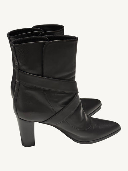 Side view of black Louis Vuitton boots with wraparound straps, pointed toes and block heels.