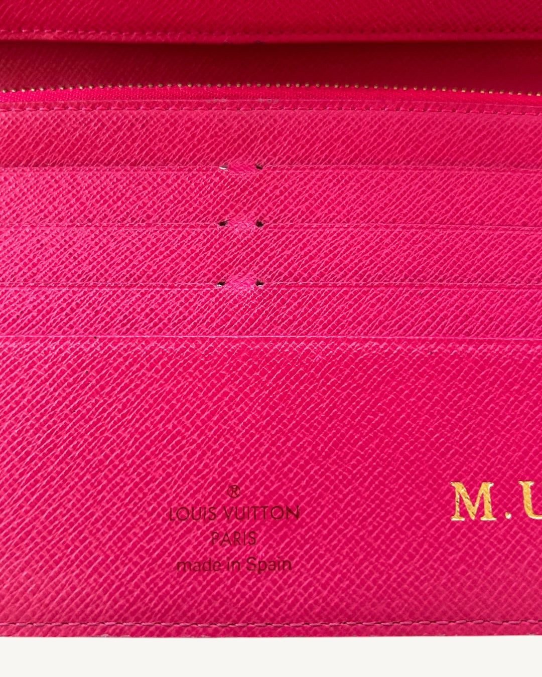 Louis Vuitton Paris Made in Spain stamp beside gold-foil M.U initials on Grenade pink leather.