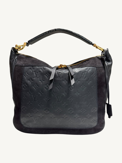 Louis Vuitton Audacieuse MM Infini — front view showing monogram empreinte embossed leather panel, tonal suede upper, flat leather top handle and gold-tone zipper hardware

