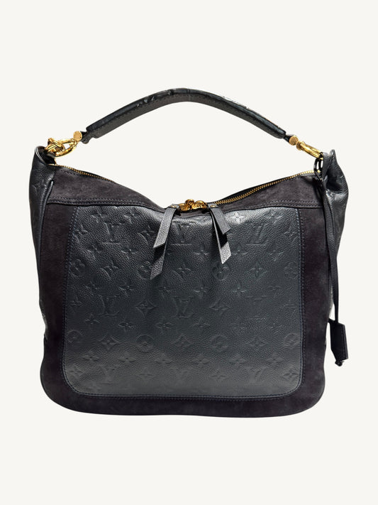 Louis Vuitton Audacieuse MM Infini — front view showing monogram empreinte embossed leather panel, tonal suede upper, flat leather top handle and gold-tone zipper hardware

