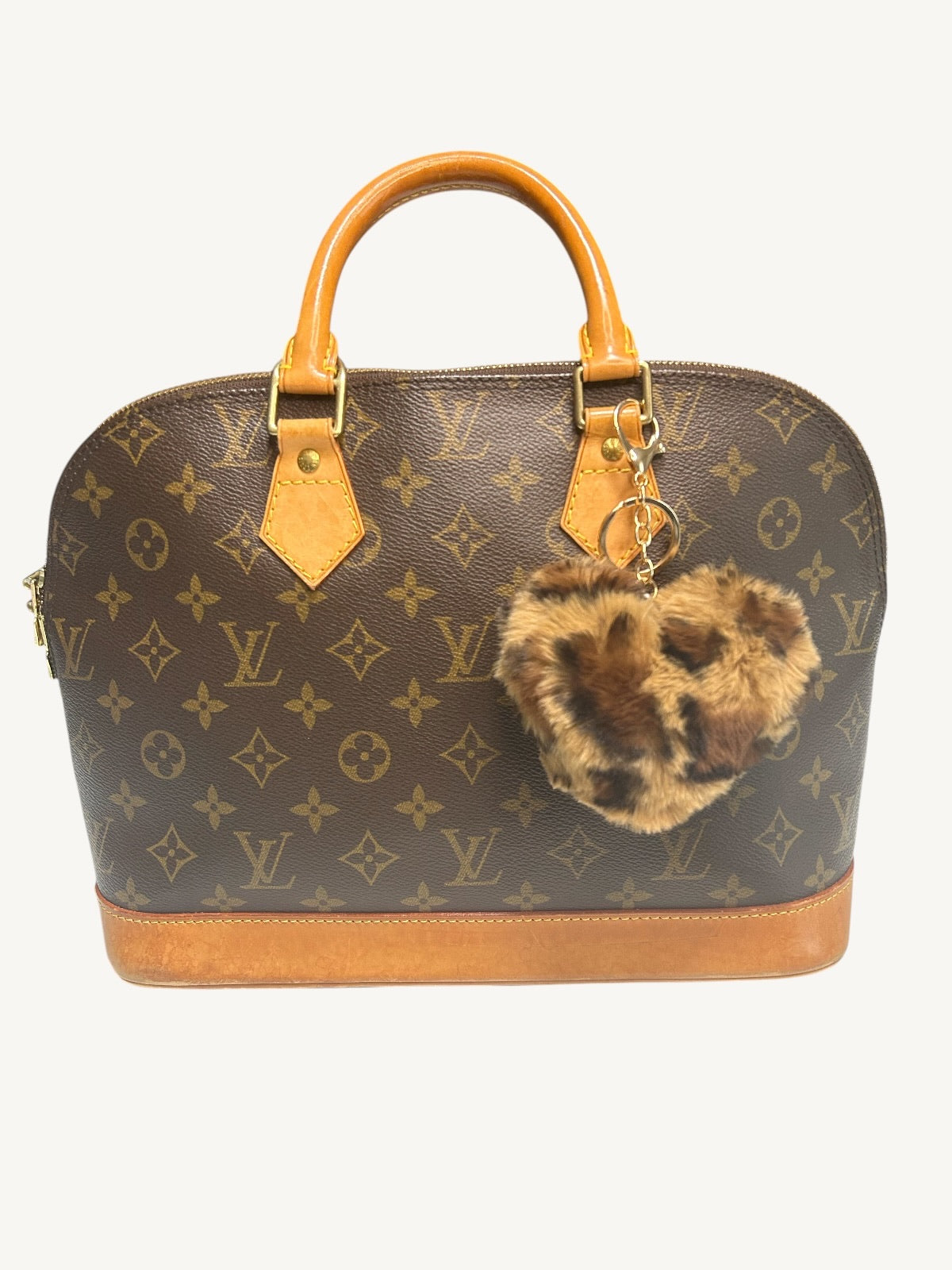 Louis Vuitton monogram canvas dome handbag with tan leather handles and base, featuring a leopard-print faux fur keychain charm.