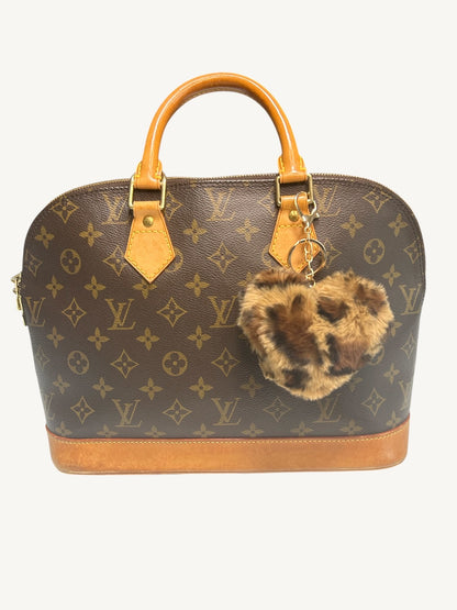 Louis Vuitton monogram canvas dome handbag with tan leather handles and base, featuring a leopard-print faux fur keychain charm.