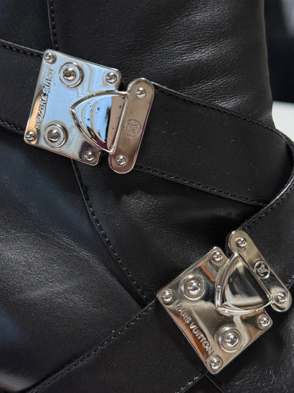 Close-up of silver-tone S-Lock hardware, showing small dark spots on the upper clasp and stitched leather straps.