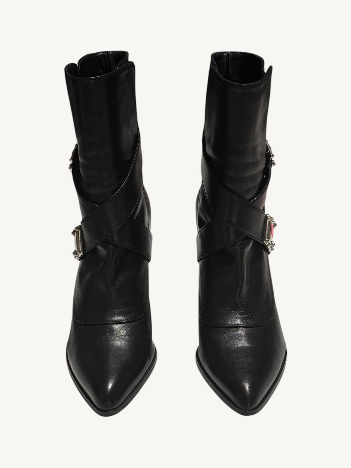Front view of black Louis Vuitton ankle boots with pointed toes and criss-cross leather straps.