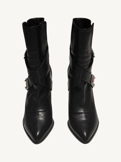 Front view of black Louis Vuitton ankle boots with pointed toes and criss-cross leather straps.