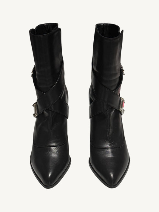 Front view of black Louis Vuitton ankle boots with pointed toes and criss-cross leather straps.