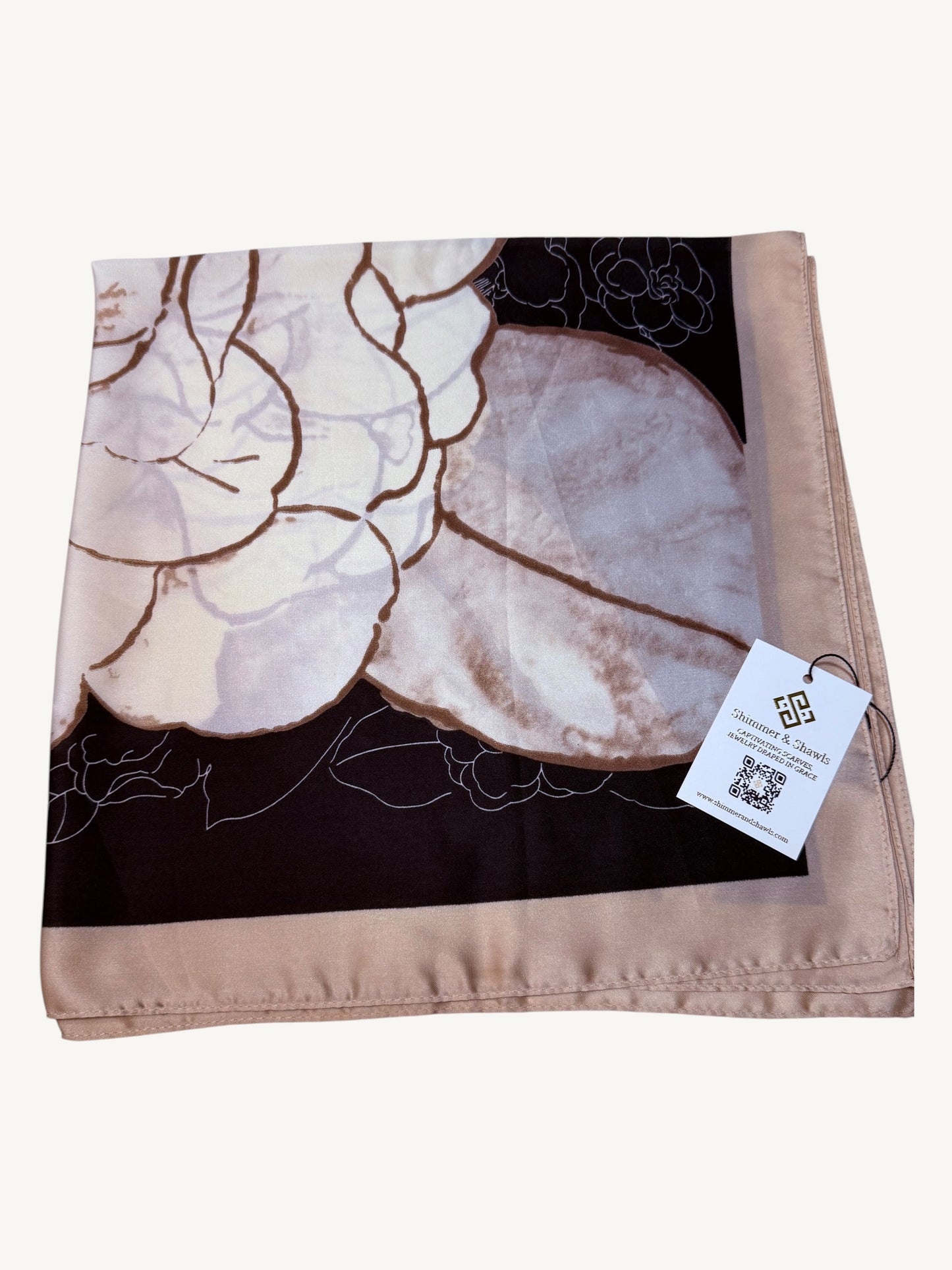 The Vendôme – folded square scarf with Shimmer & Shawls branded tag showing champagne camel border