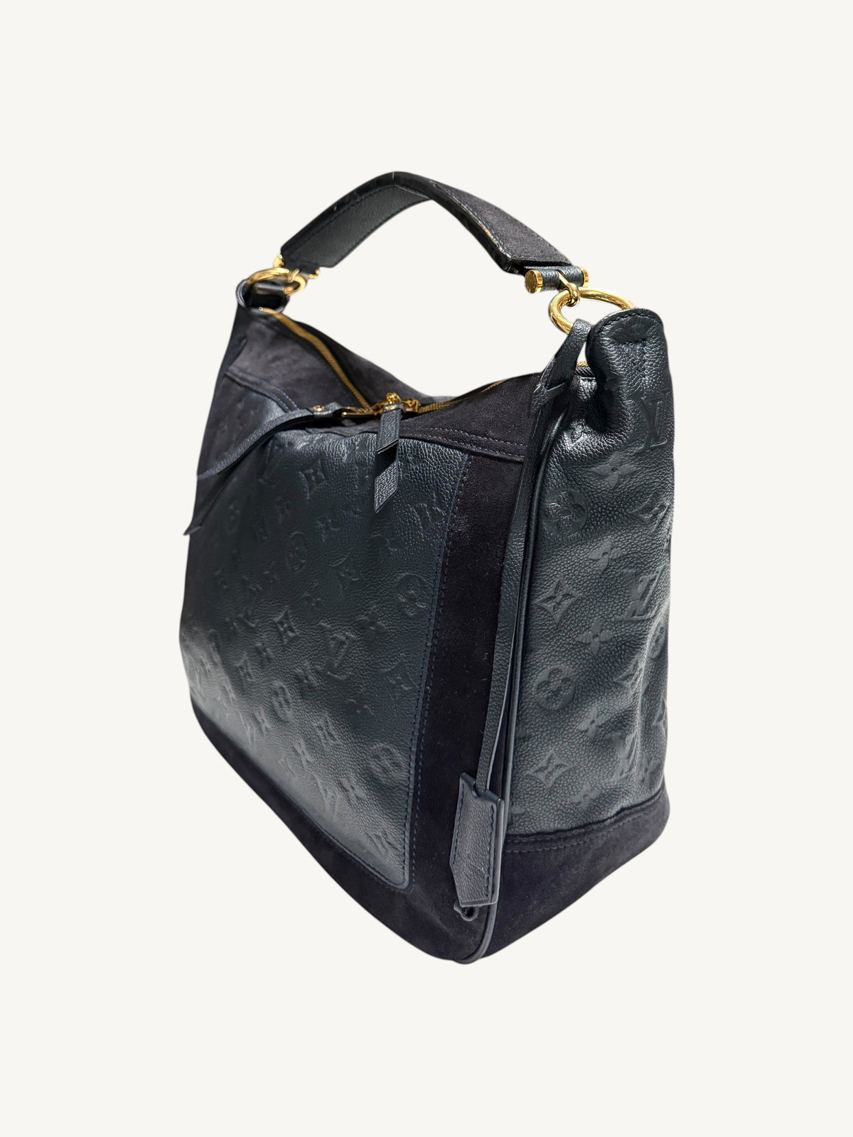 Louis Vuitton Audacieuse MM Infini — three-quarter side view showing monogram empreinte embossing, suede panels, gold zipper hardware and flat leather top handle

