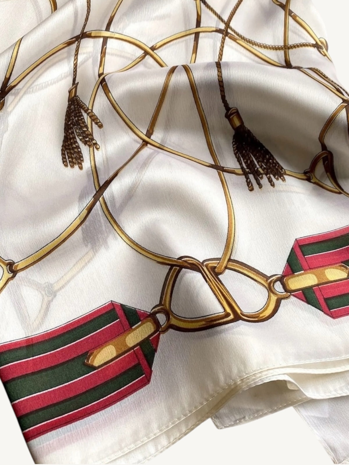The Matera – close-up of antique gold equestrian stirrup and tassel print on ivory silky satin scarf shawl wrap by Shimmer & Shawls