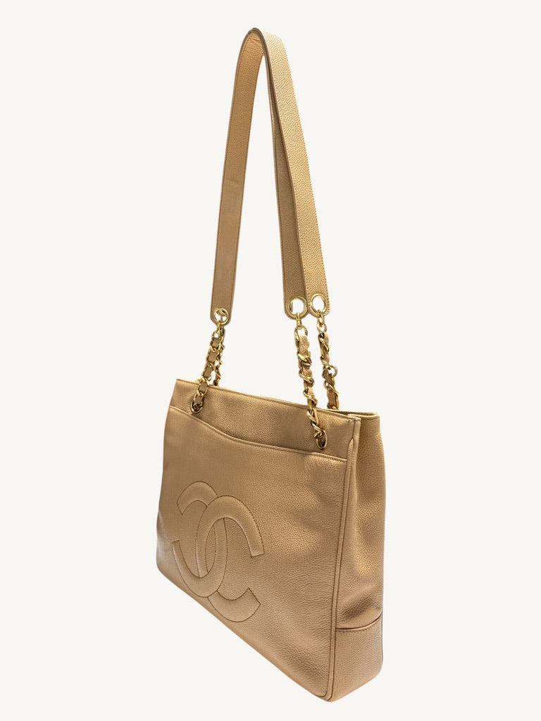 Three-quarter front view showing the Chanel CC tote’s right side and open exterior pocket