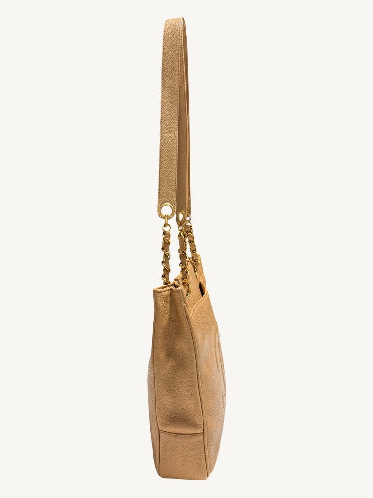 Side profile of vintage Chanel beige tote showing gusset and chain strap attachments