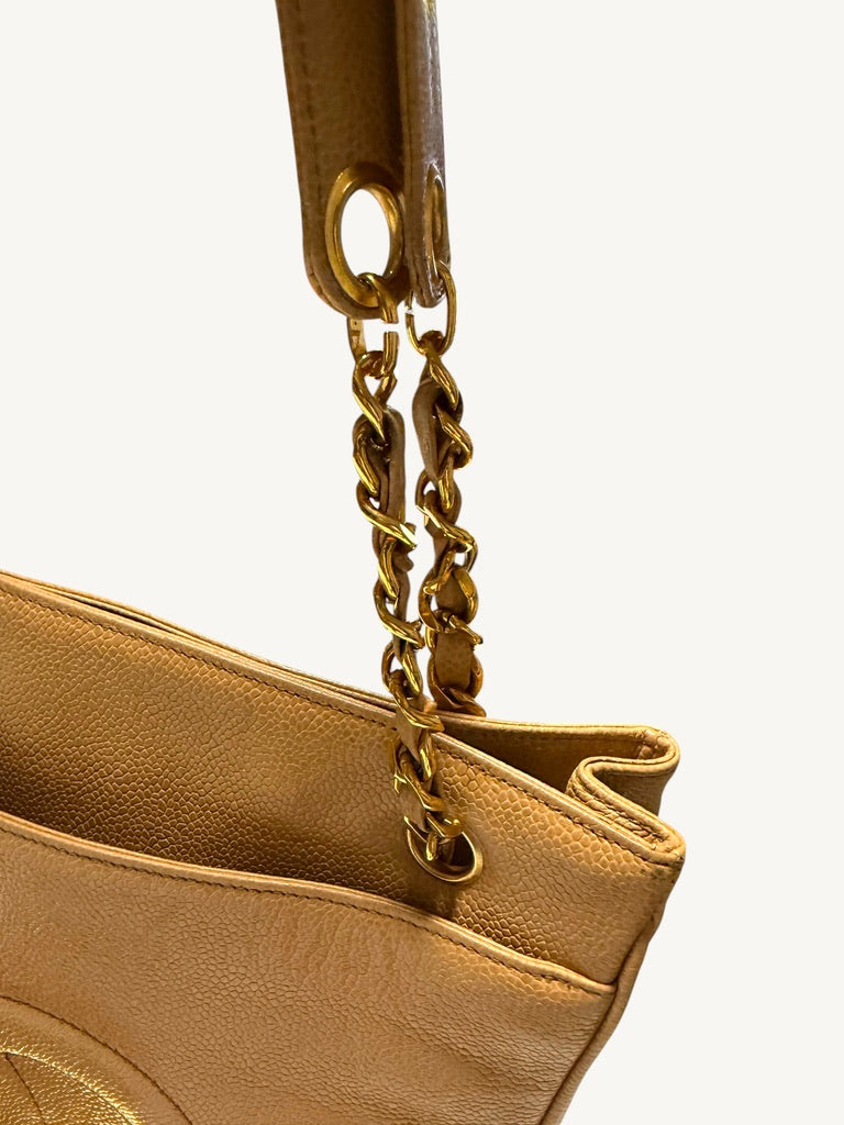 Front chain attachment and folded side gusset of beige caviar tote