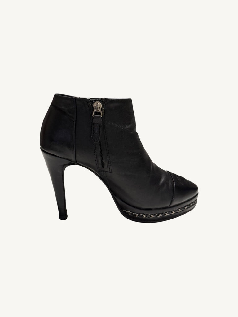 Side profile of Chanel vintage black calfskin platform ankle boot showing interior zipper and chain trim