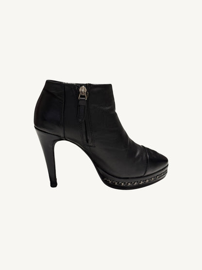 Side profile of Chanel vintage black calfskin platform ankle boot showing interior zipper and chain trim