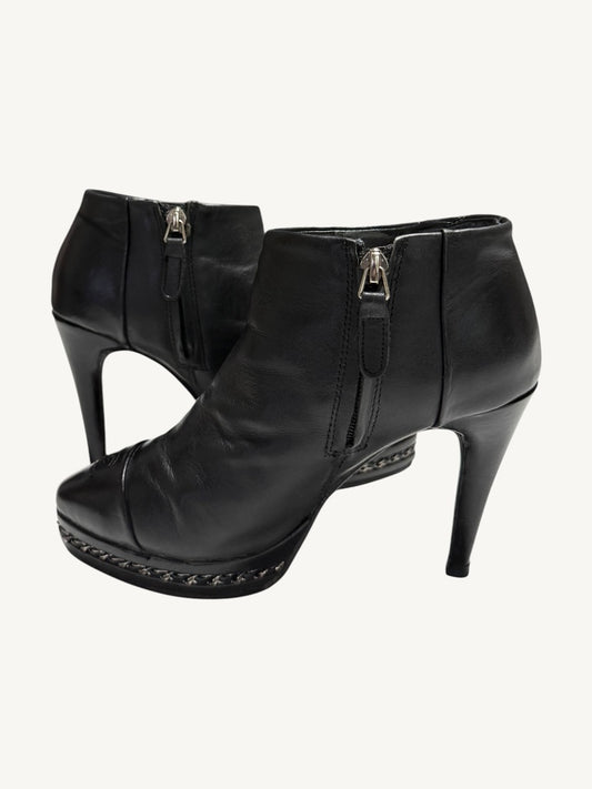 Chanel vintage black calfskin ankle boots showing interior side zippers, chain platforms and stiletto heels