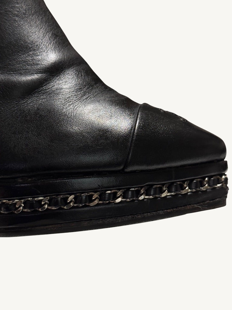 Close-up of Chanel ankle boot silver-tone chain interwoven with black leather around the platform