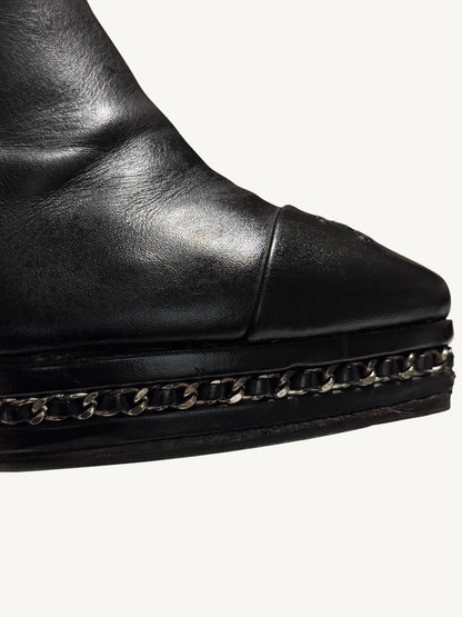 Close-up of Chanel ankle boot silver-tone chain interwoven with black leather around the platform