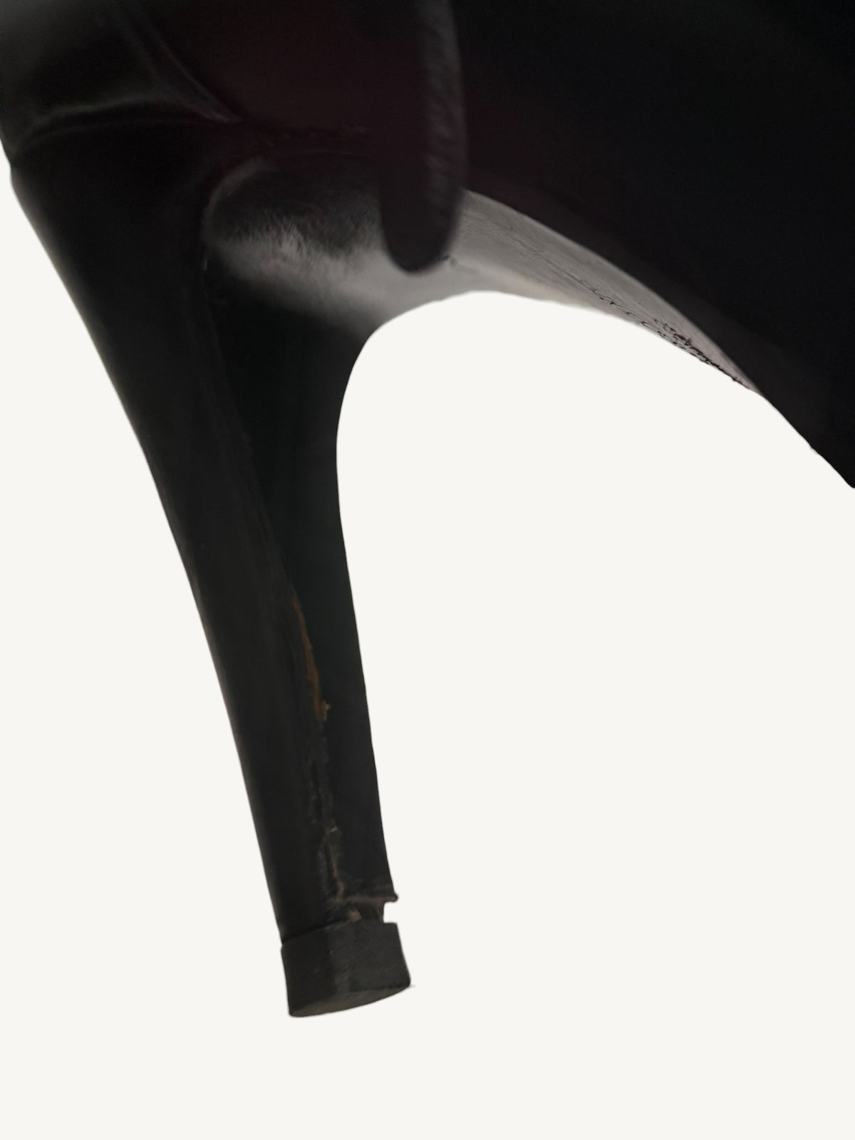 Close-up of Chanel vintage black ankle boot heel base documenting leather wrap wear and seam