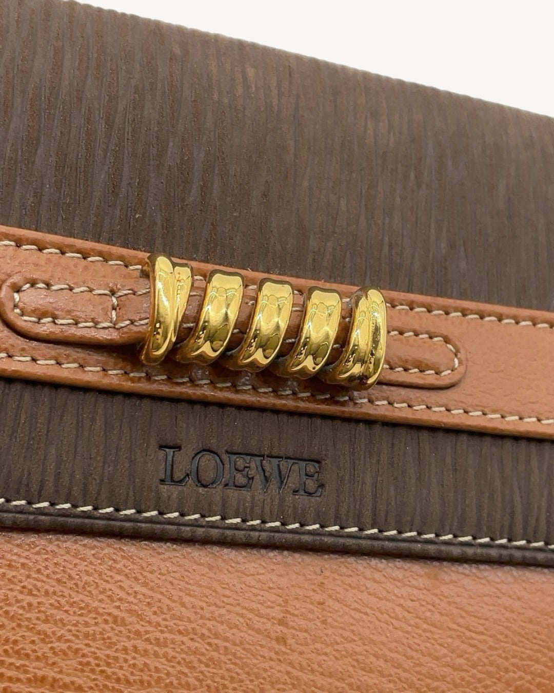 Gold-tone twisted-ring hardware and embossed Loewe logo