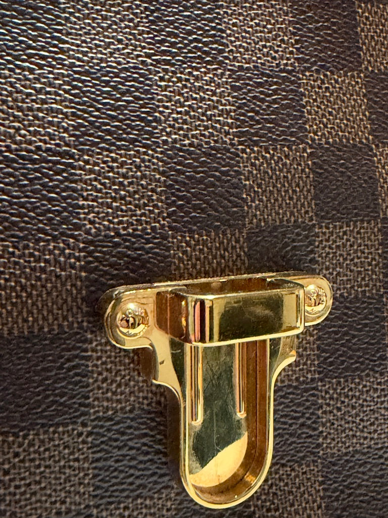 Louis Vuitton Clapton Backpack — Tight detail of lower gold-tone closure and textured canvas
