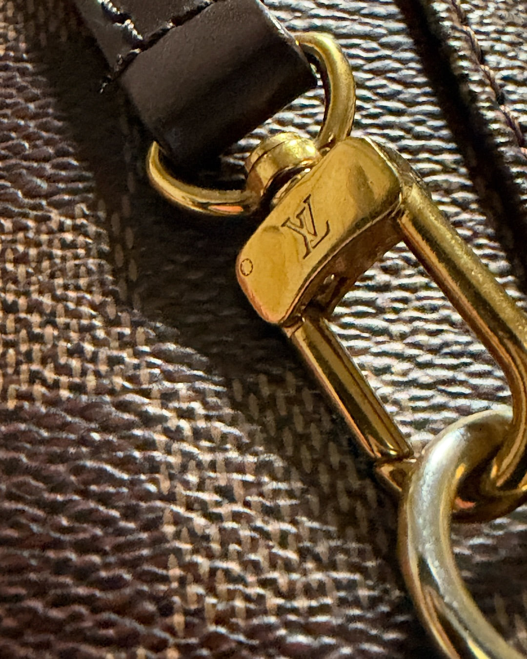 Louis Vuitton Clapton Backpack — LV-engraved gold-tone swivel clasp attached to brown leather strap