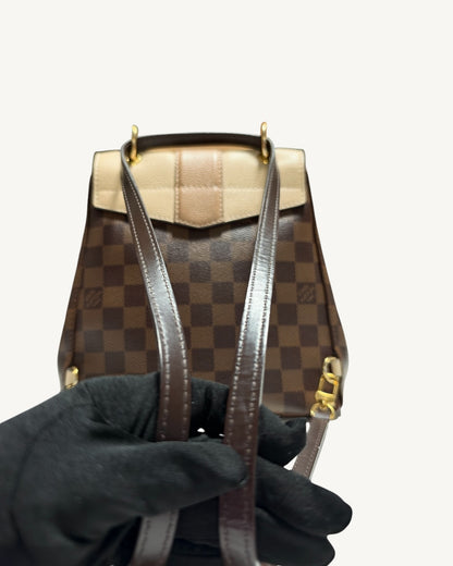 Louis Vuitton Clapton Backpack — Brown leather strap stitching held in a gloved hand with rear of backpack visible
