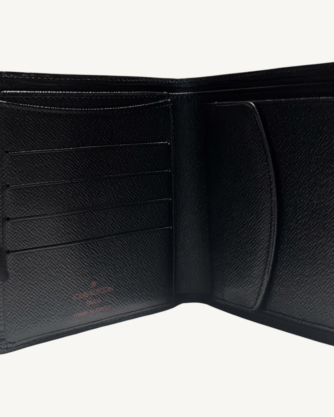 Close-up of black cross-grain leather interior with card slots and Louis Vuitton stamp