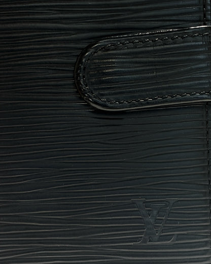 Close-up of embossed LV logo, black Epi leather texture and stitched leather snap tab