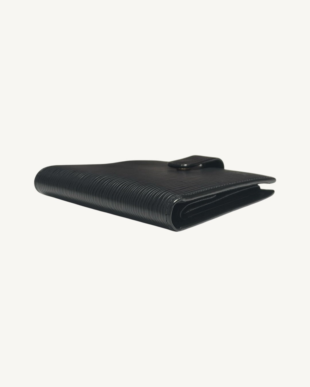Side angle of closed Louis Vuitton black Epi wallet showing folded leather edges