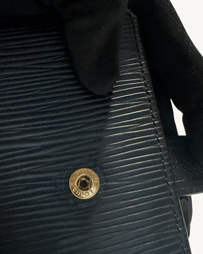 Close-up of Louis Vuitton engraved gold-tone snap button on black Epi leather