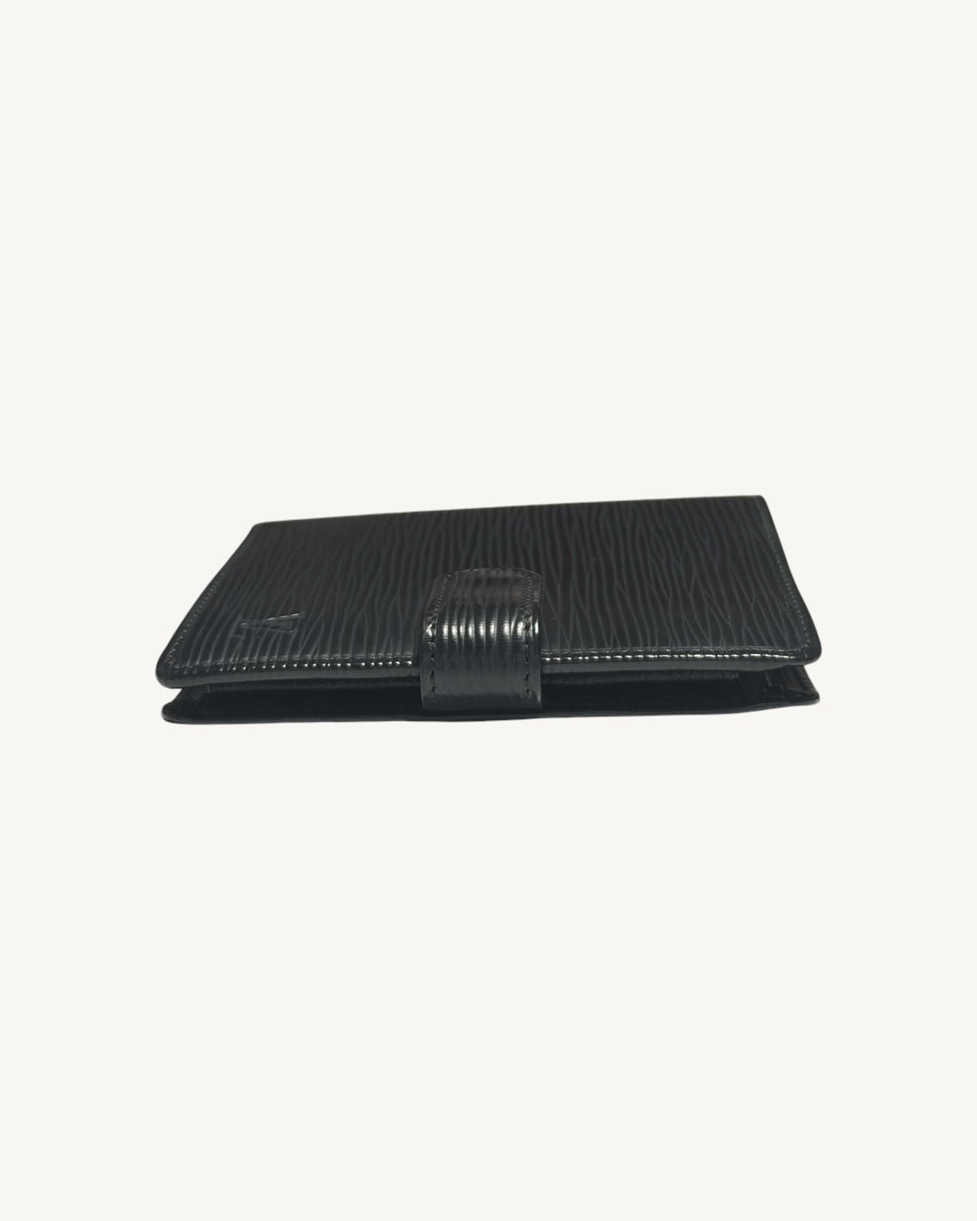Top edge view of closed Louis Vuitton wallet with leather snap-tab closure