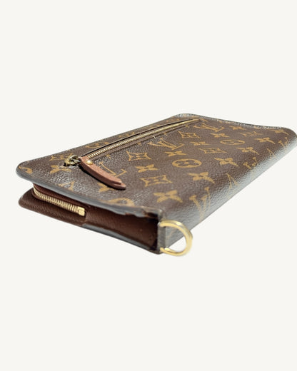 Three-quarter view of brown Monogram wallet with D-ring in foreground and leather zip pull