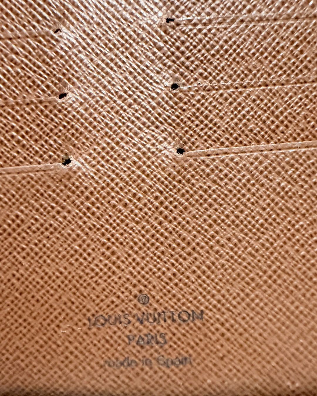 Close-up of Louis Vuitton Paris made in Spain interior stamp beneath card slot stitching
