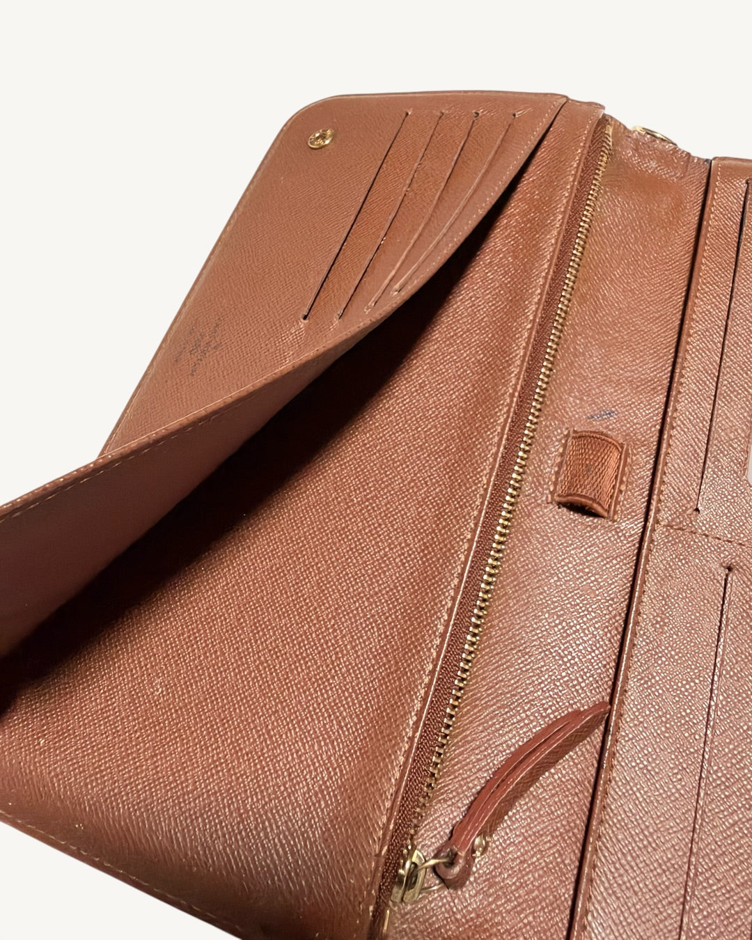 Interior slip pocket opened behind card panel beside central zipper and pen loop