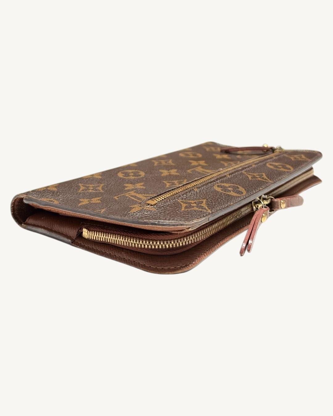 Angled side view of Insolite wallet showing curved zippered compartment and paired leather pulls