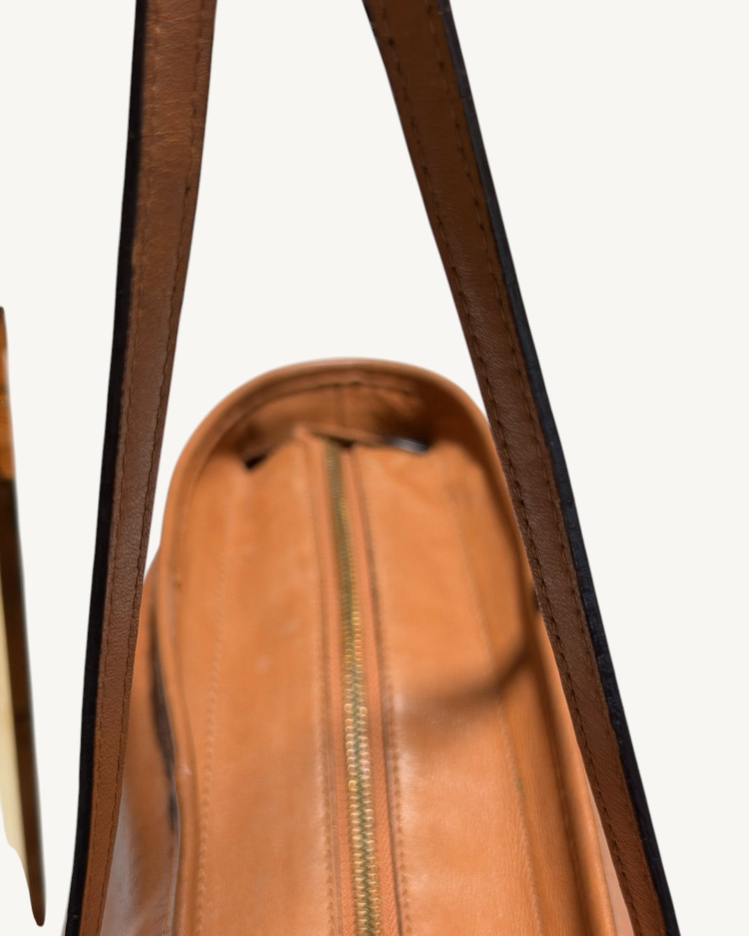 View between MCM tote shoulder straps showing darkened strap edges and closed top zipper.
